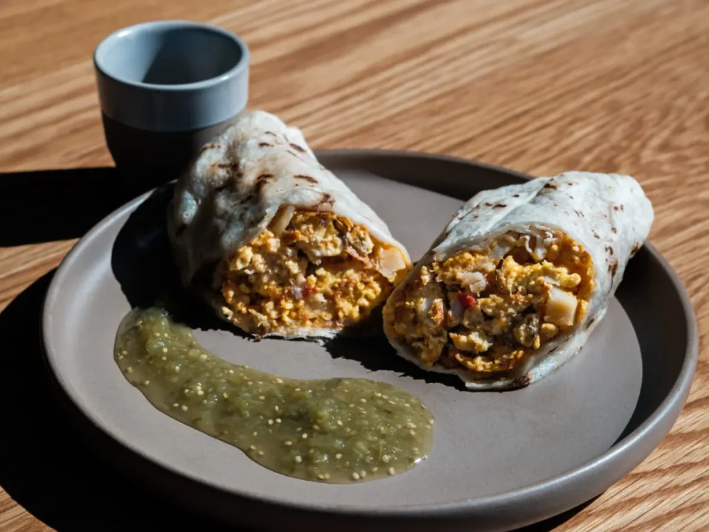 Breakfast burrito with eggs and potatoes served with green salsa at Cafecito